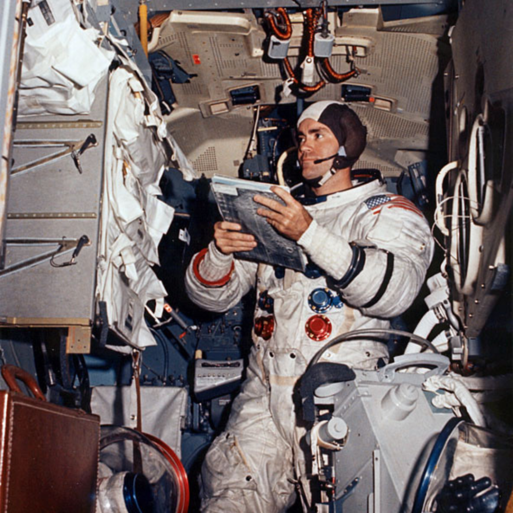 Fred Haise works in the LM simulator. The Environmental Control System (ECS) is on the righthand side of the image. 7 April 1970. Scan by Ed Hengeveld.