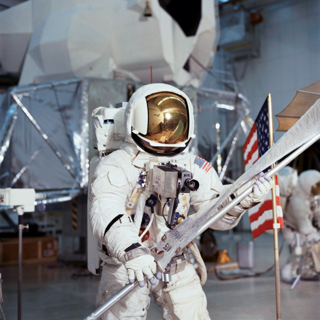 Fred Haise carries the Solar Wind Collector (SWC) during training. Note the black strap on Haise's right forearm. Note, also, that Fred has a 16-mm Data Acquisition Camera (DAC) mounted on his RCU. 4 February 1970. Scan courtesy NASA Johnson. S70-27038 ( 172k )