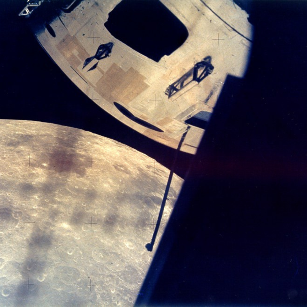 View thru the LM rendezvous window of the Moon beyond the Command Module. Scan by Kipp Teague.