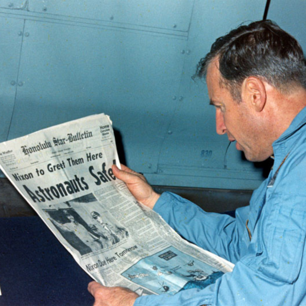 Jim Lovell reads a newspaper account of the Apollo 13 recovery. 17 April 1970. Scan by Ed Hengeveld.