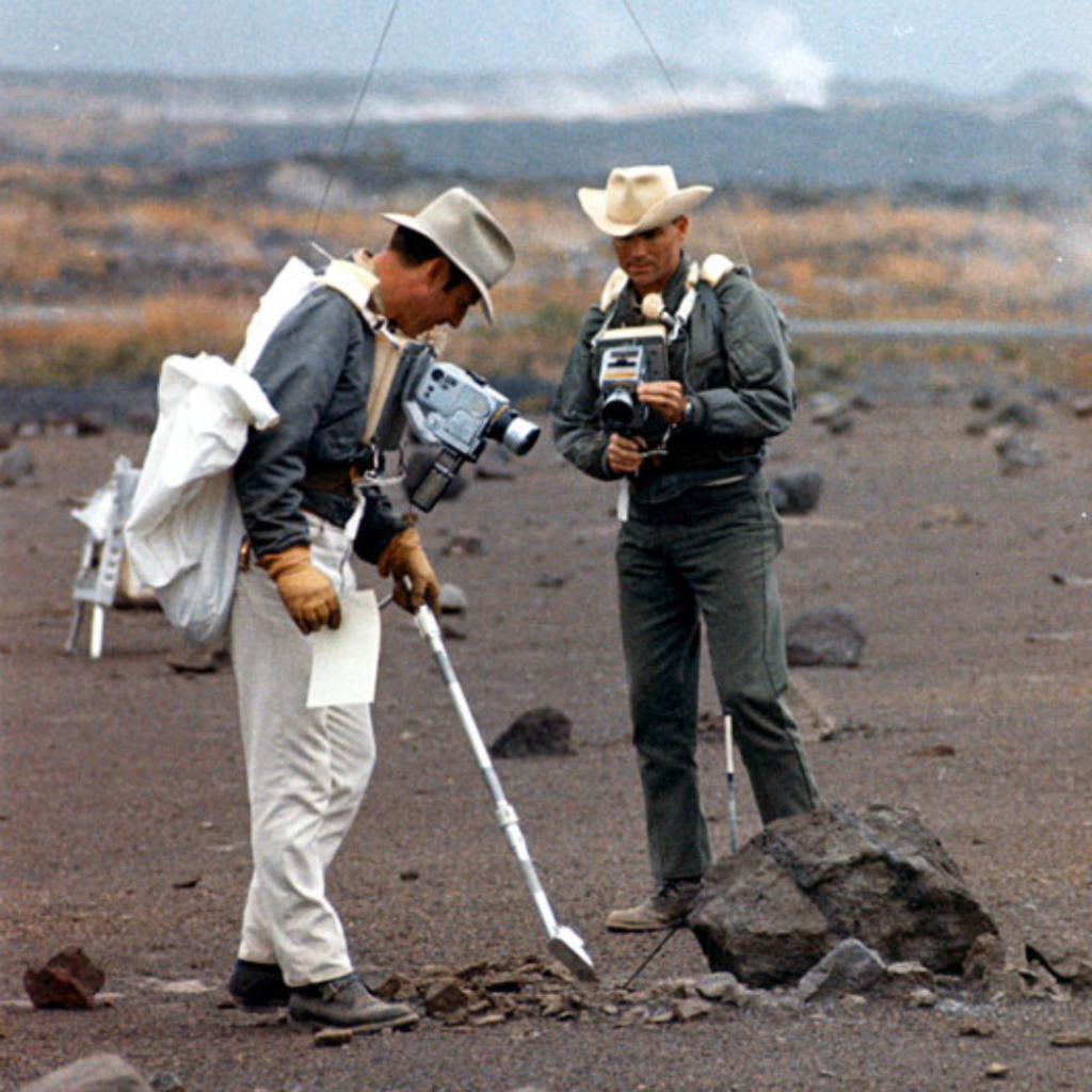 Jim Lovell (left) points with his scoop while Fred Haise takes a documentation photograph during the December 17-20 field trip to Hawaii. December 1969. Scan by Ed Hengeveld.