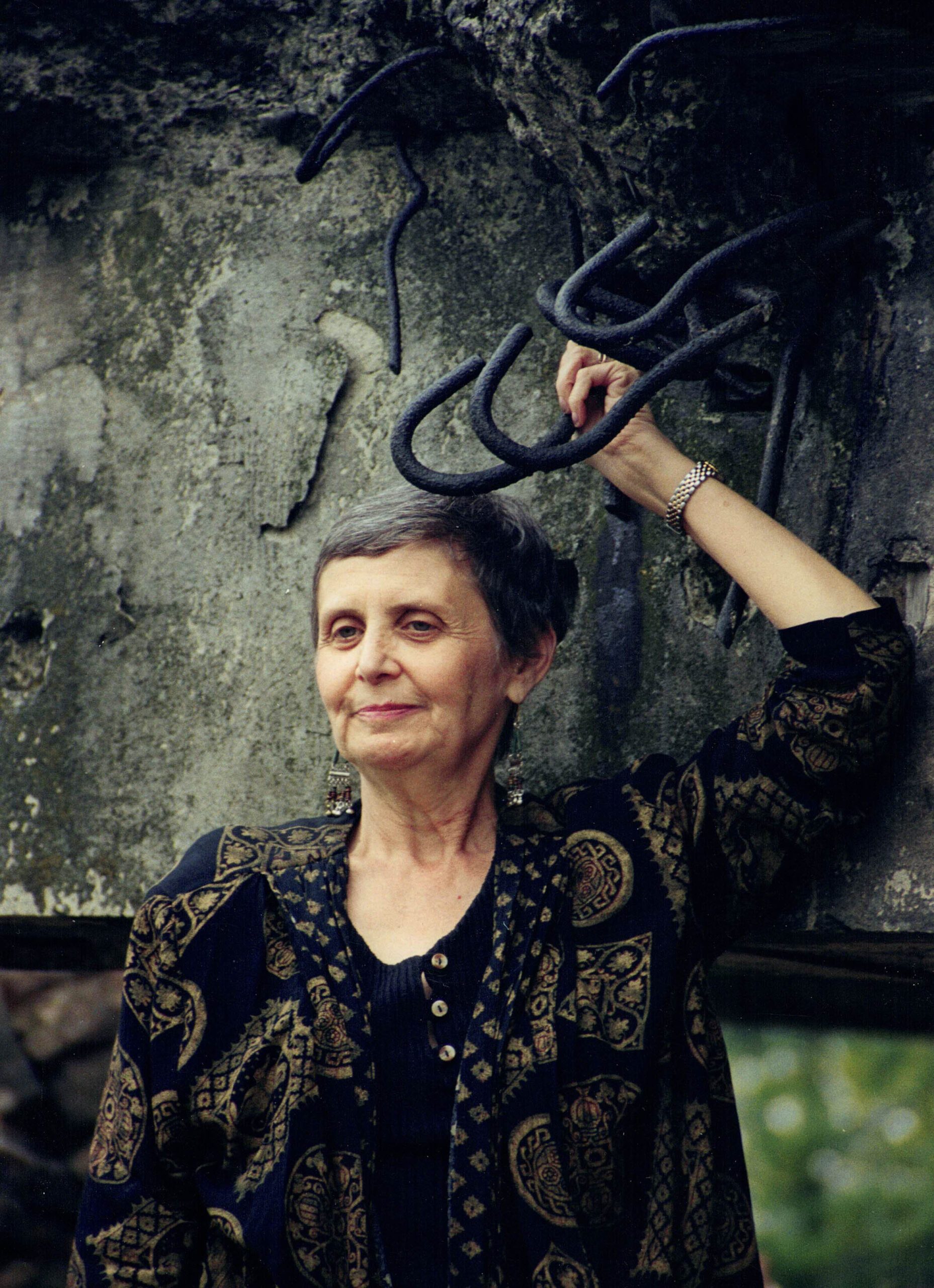 Tova standing among the remains of a gas chamber on her first return to Auschwitz in 1999.